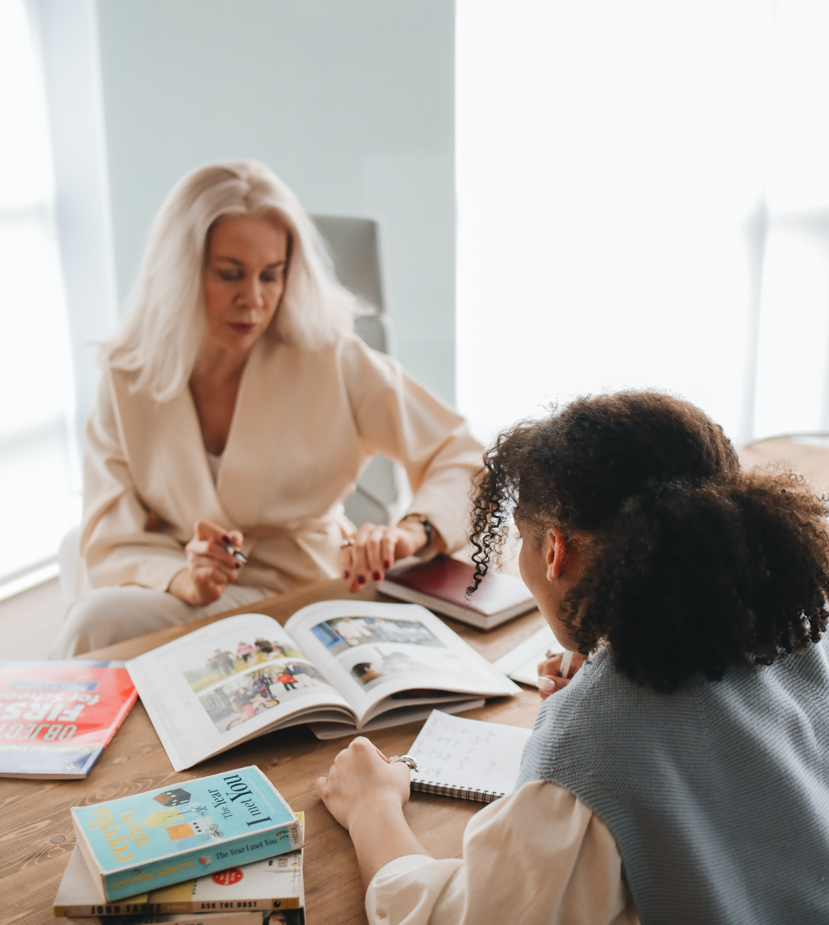 A student and an educator reading a book together.